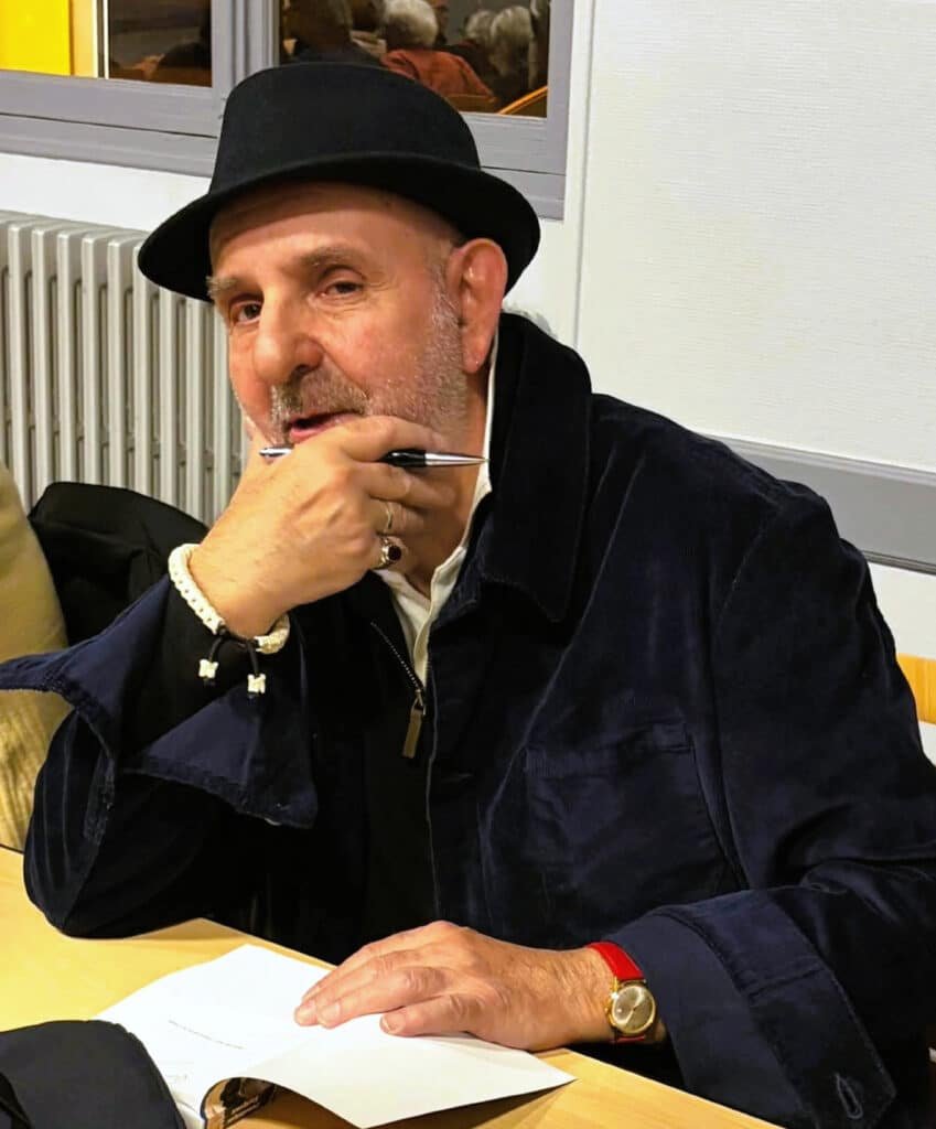 Dominique Farigoux, stylo à la main, devant son livre ouvert lors de la séance de dédicaces.